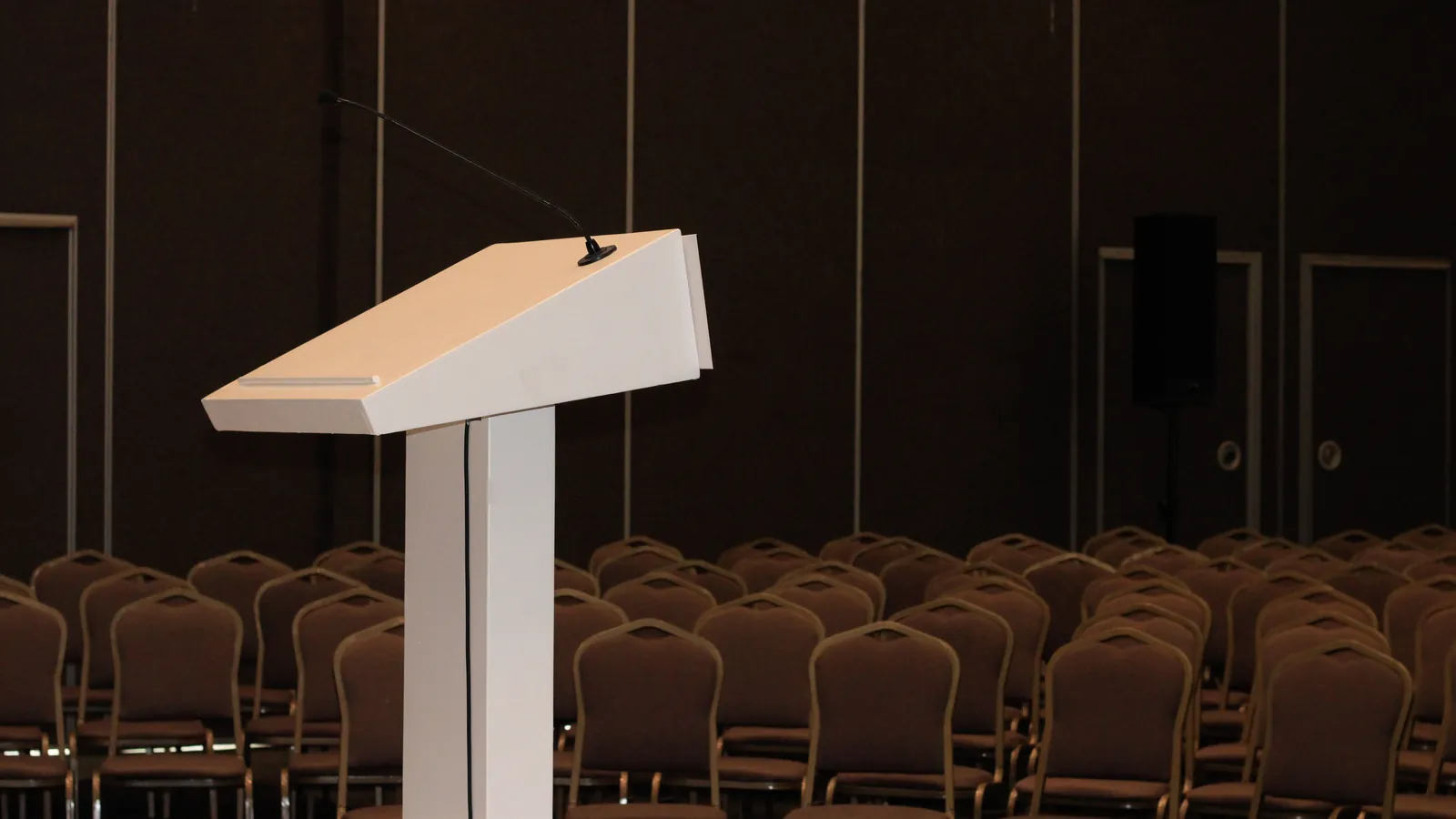 Empty lectern and microphone before rows of chairs