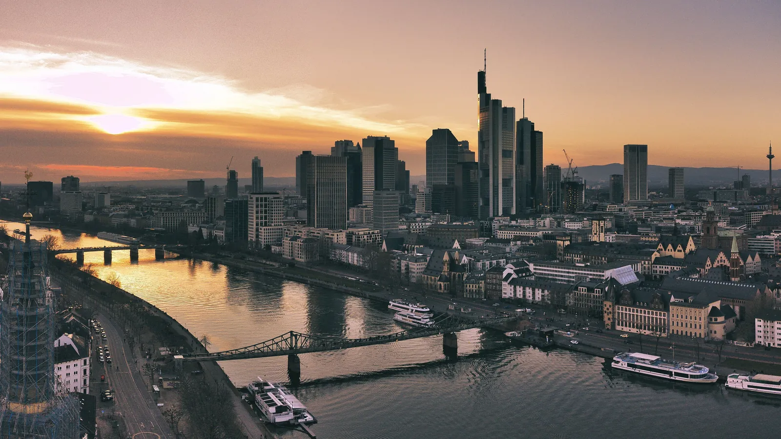 City towers and bridges beside a river at sunset
