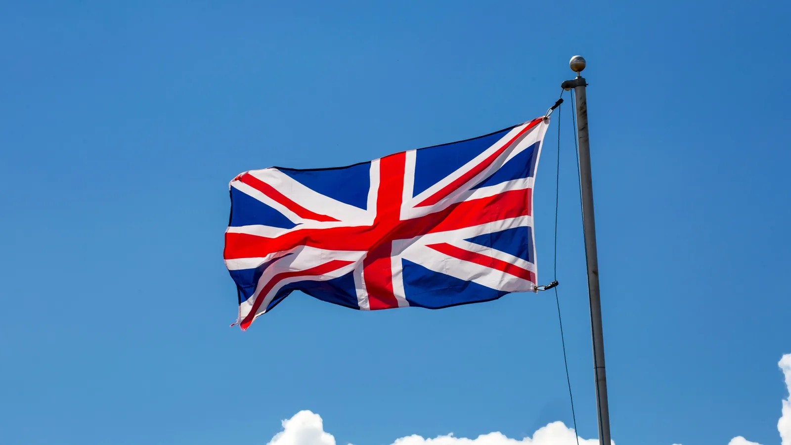 Red white and blue flag waving against a blue sky