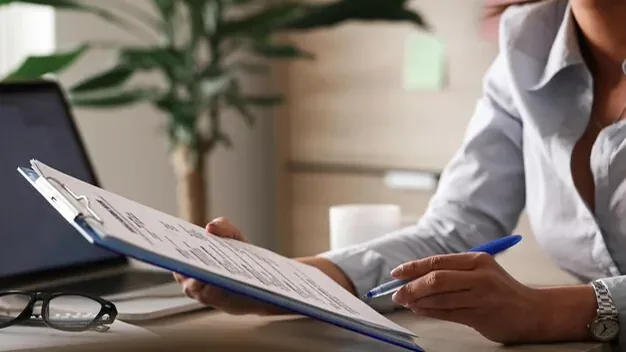 Unrecognizable female entrepreneur analyzing business reports while working on paperwork in the office