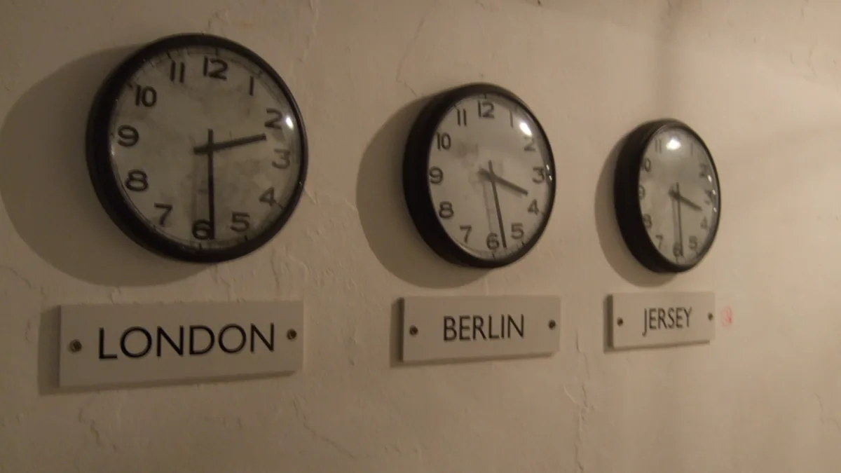 Three wall clocks showing the time in London, Berlin and Jersey