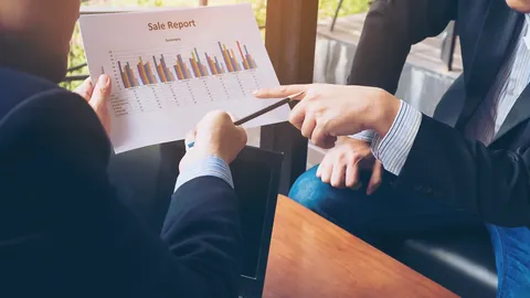 Two businesspeople reviewing a printed chart together