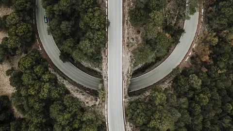 Aerial view of two roads splitting apart through a forest