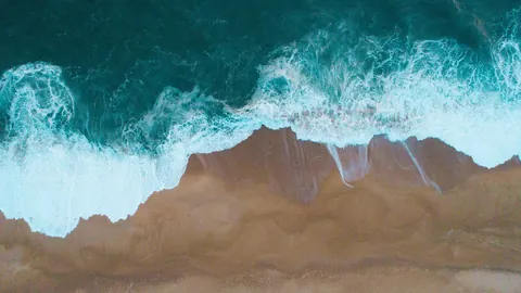 Aerial view of ocean waves breaking on a beach