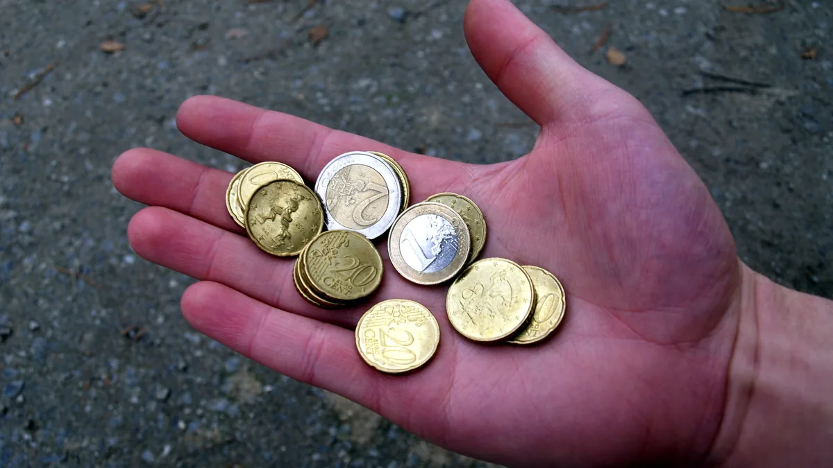 An open hand holding a few euro coins