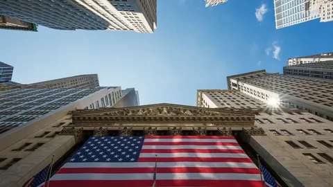 Skyscrapers and a US flag on a stock exchange building, seen from below
