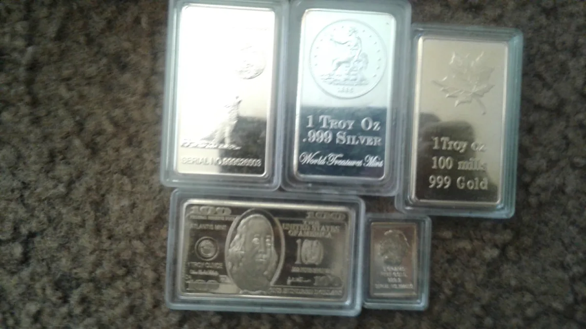 Small silver and gold bullion bars laid side by side