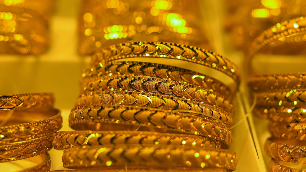 Stacks of patterned gold bangles in a jewellery shop display