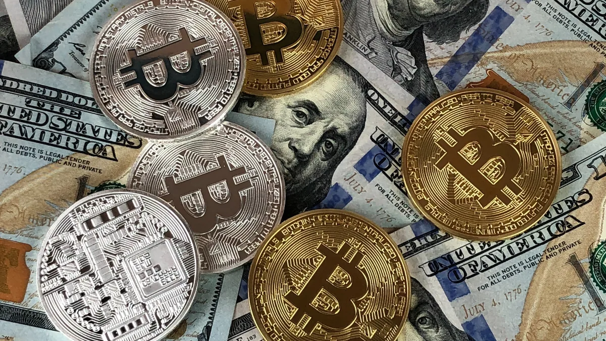 Metal bitcoin tokens lying on a spread of US dollar bills