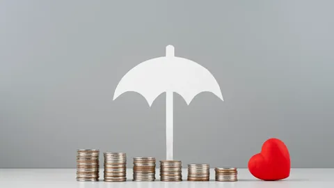 Paper umbrella sheltering stacks of coins next to a red heart