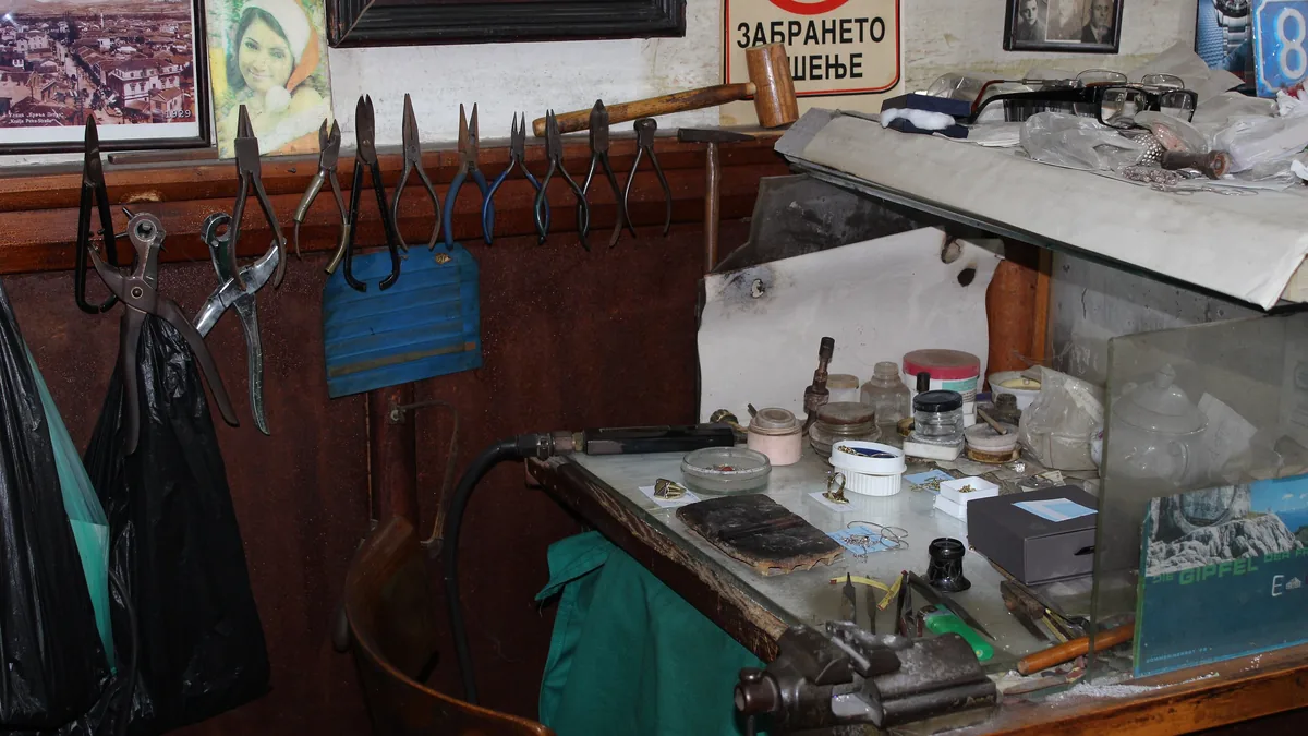 A goldsmith’s workbench with tools laid out in a small workshop
