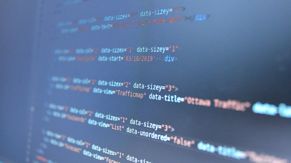 Lines of colour-highlighted program code on a blurred screen