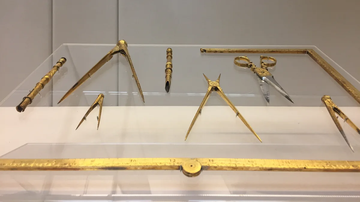 Brass compasses, dividers and a ruler from a set of old drawing instruments