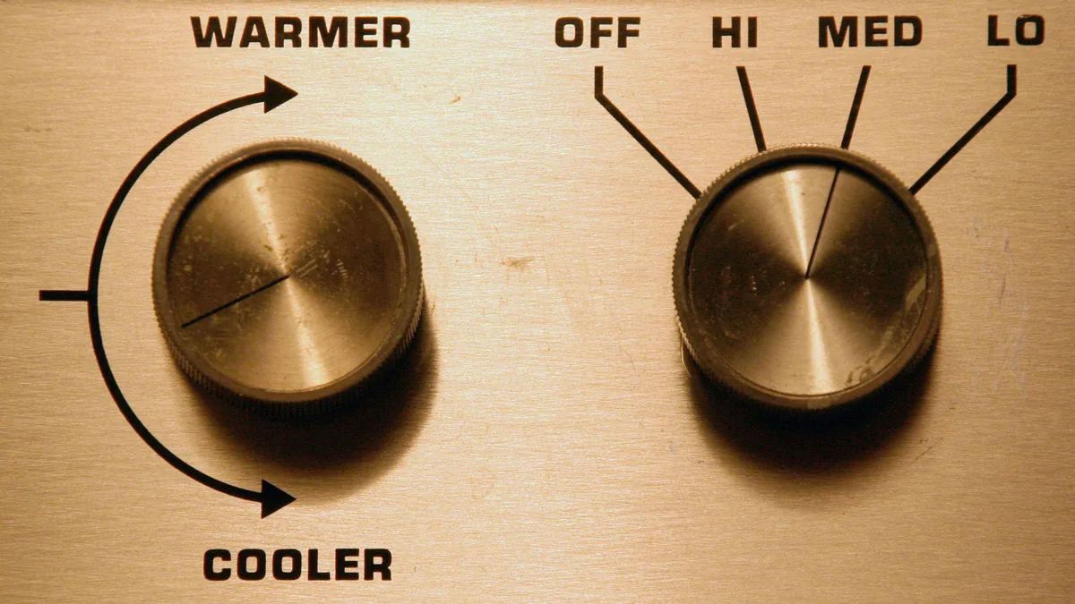 Two brass control knobs with printed scales and labels for adjusting a setting