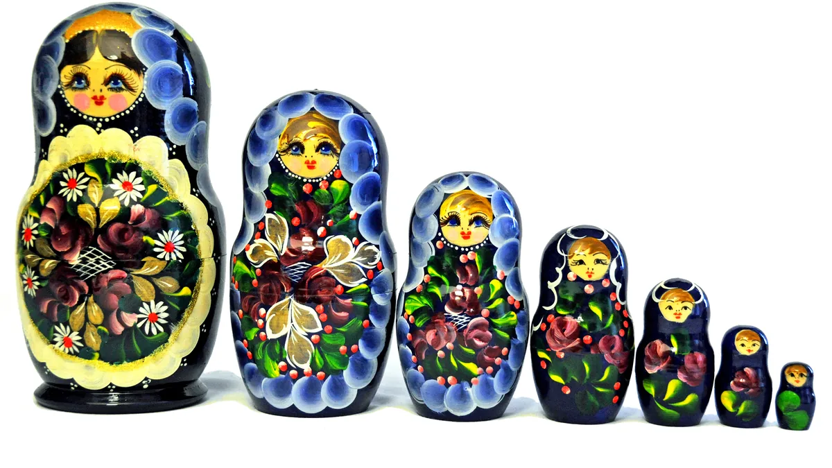 A set of painted nesting dolls lined up from largest to smallest