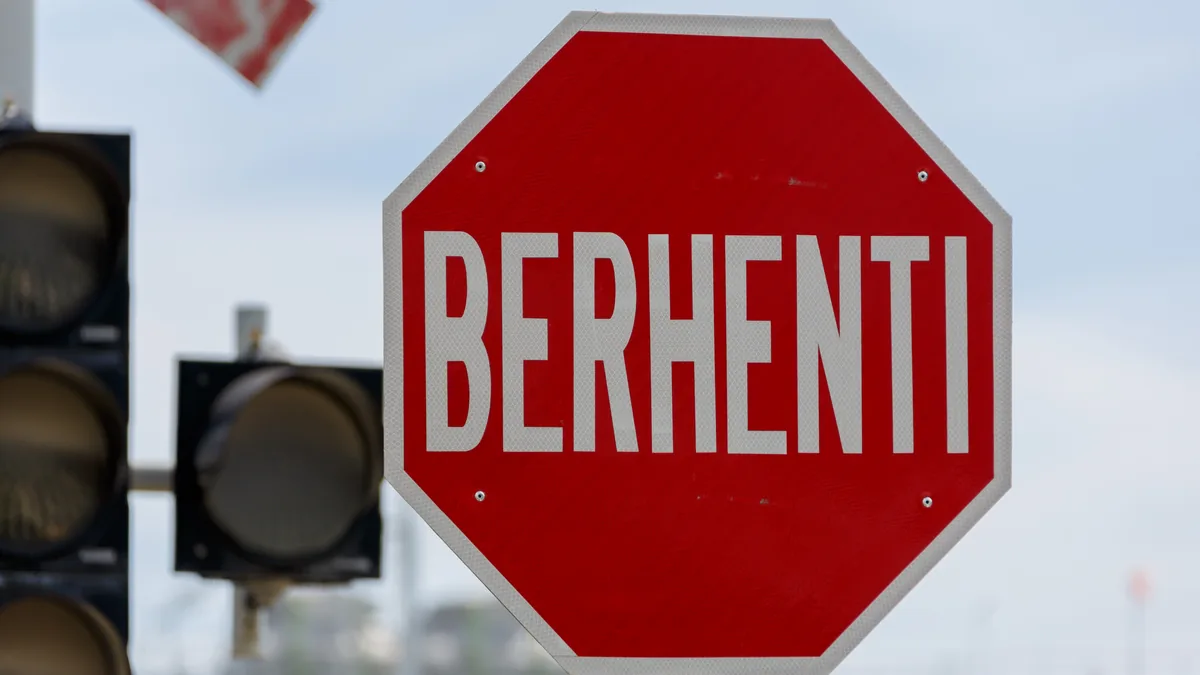 A red octagonal stop sign beside a traffic light