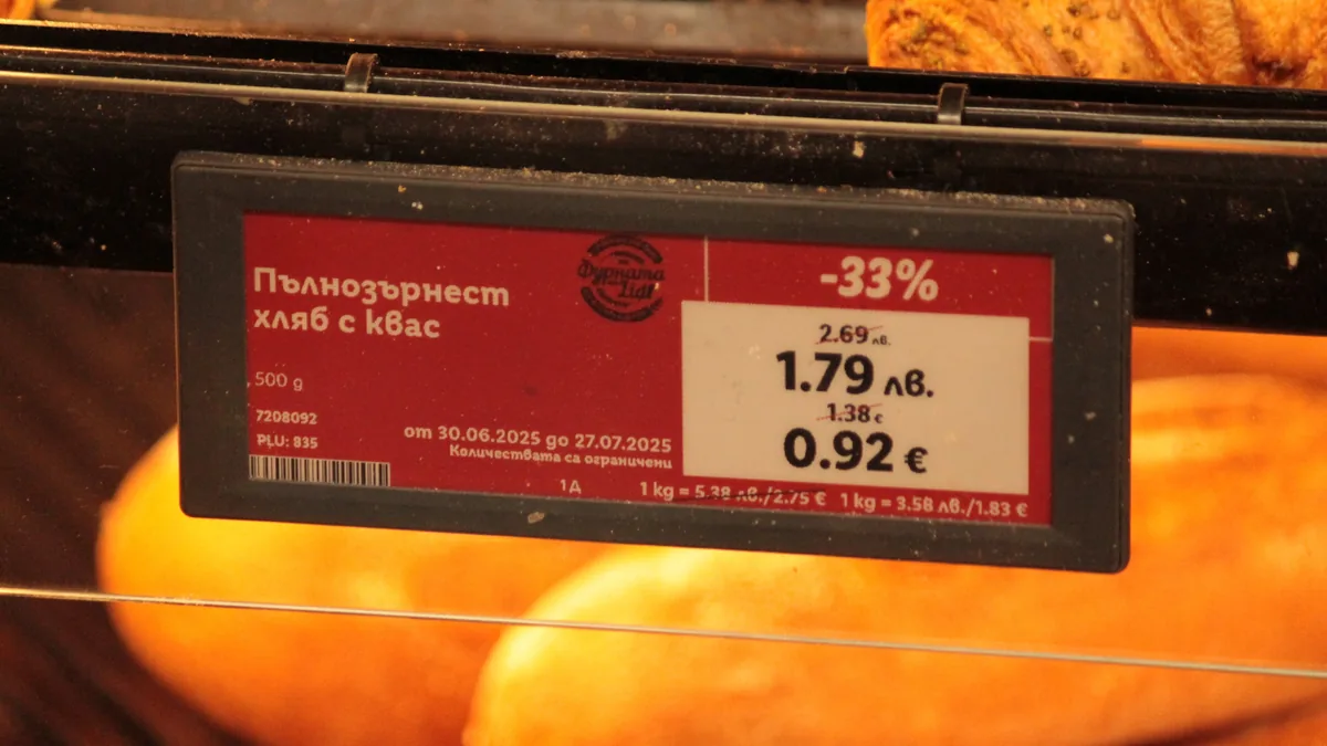 A shop shelf price label showing the same loaf priced in two currencies