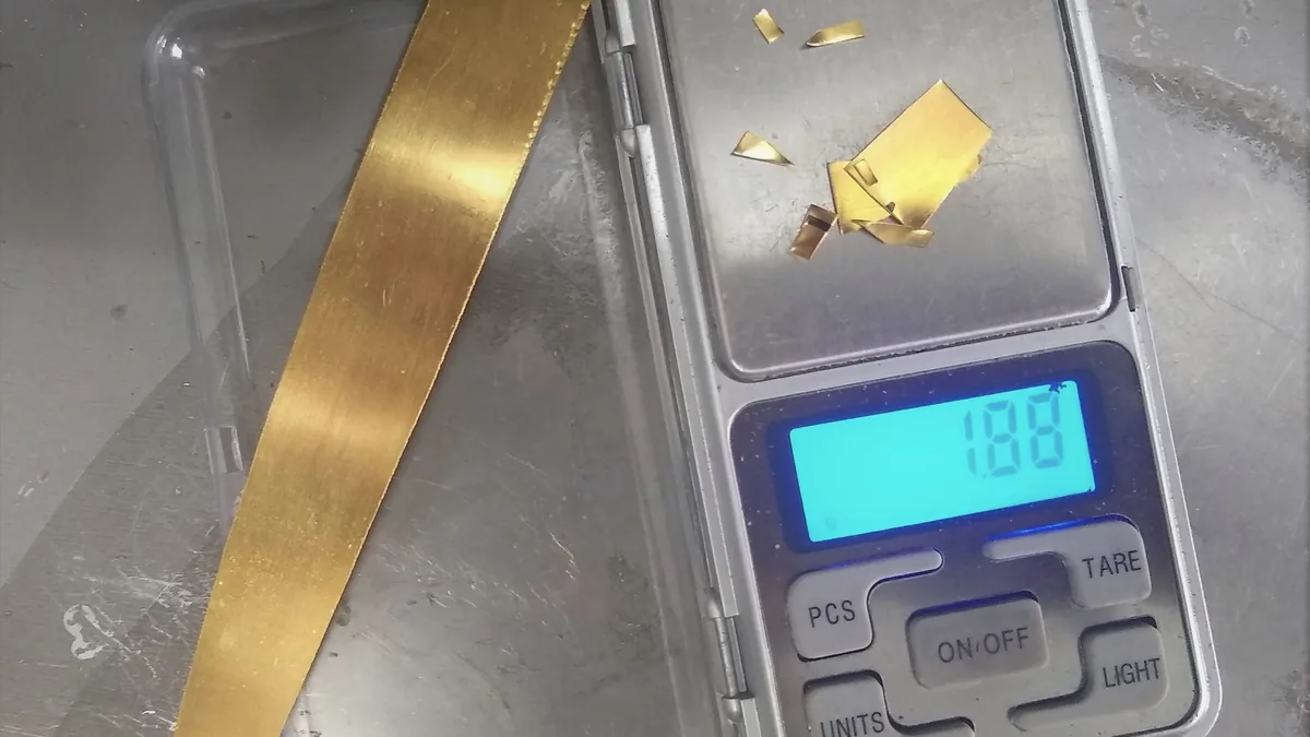 Fine gold being weighed on a digital jeweller’s scale