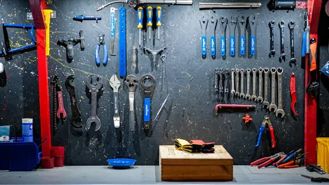 Wall of hand tools hanging on a dark pegboard