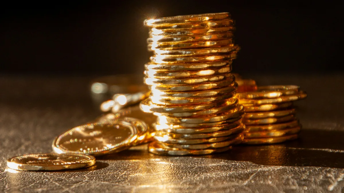 Stacks of gold coins on a dark textured surface